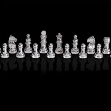 Pièces d'échecs argentées du Chess Genius Pro alignées sur fond noir