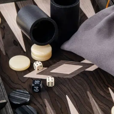 Détail des gobelets à dés, pions en nacre et pochette en tissu sur le plateau
