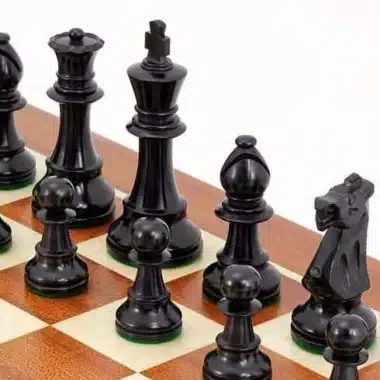 Pièces noires en buis vues de près sur l'échiquier en acajou
