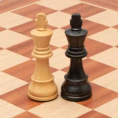 Rois clair et noir Classic XIX face à face sur l'échiquier en acajou