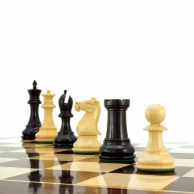 Pièces d'échecs en buis et ébène alignées sur l'échiquier en perspective