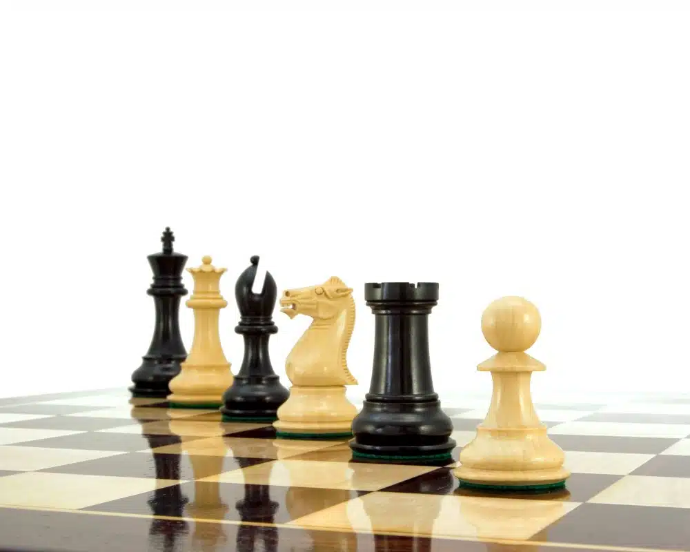 Pièces d'échecs en buis et ébène alignées sur l'échiquier en perspective
