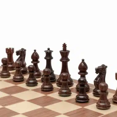 Pièces d'échecs foncées en bois de rose alignées sur l'échiquier