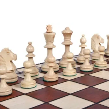 Détail des pièces d'échecs claires en bois disposées sur l'échiquier