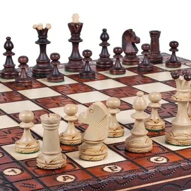 Pièces d'échecs disposées en diagonale sur l'échiquier gravé, vue d'angle